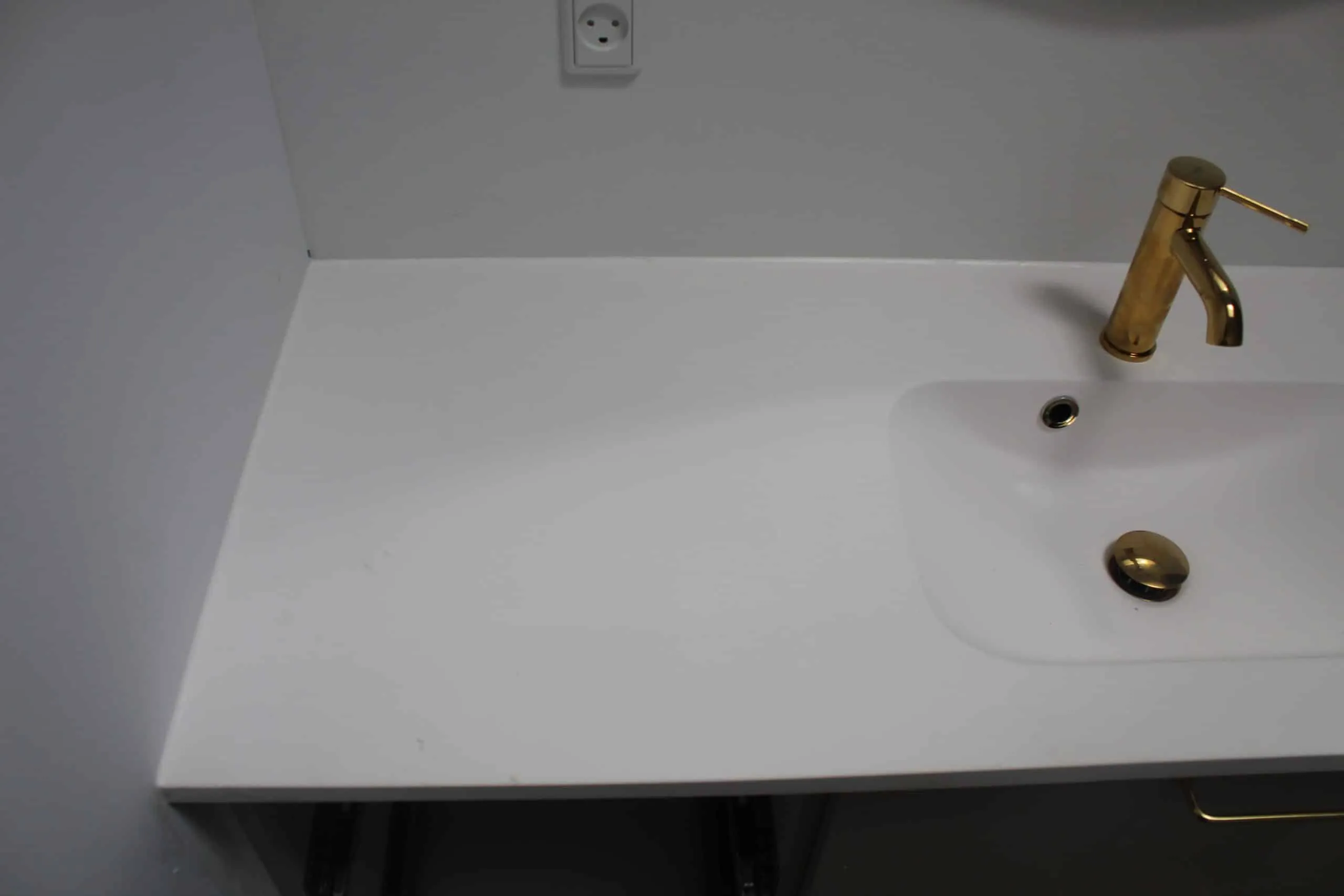 Hvid bordplade med vask og en ny fuge mod væggen