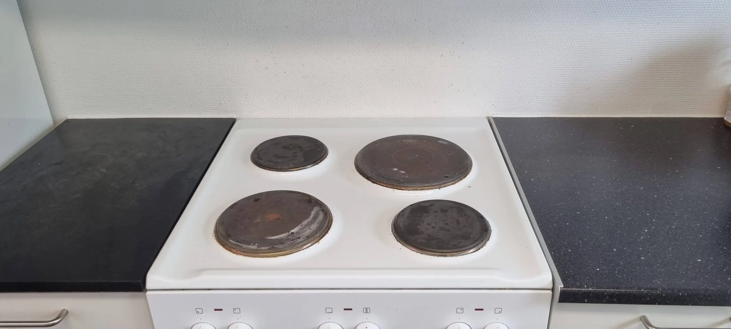 Hvidt komfur mellem to bordplader med nye fuger