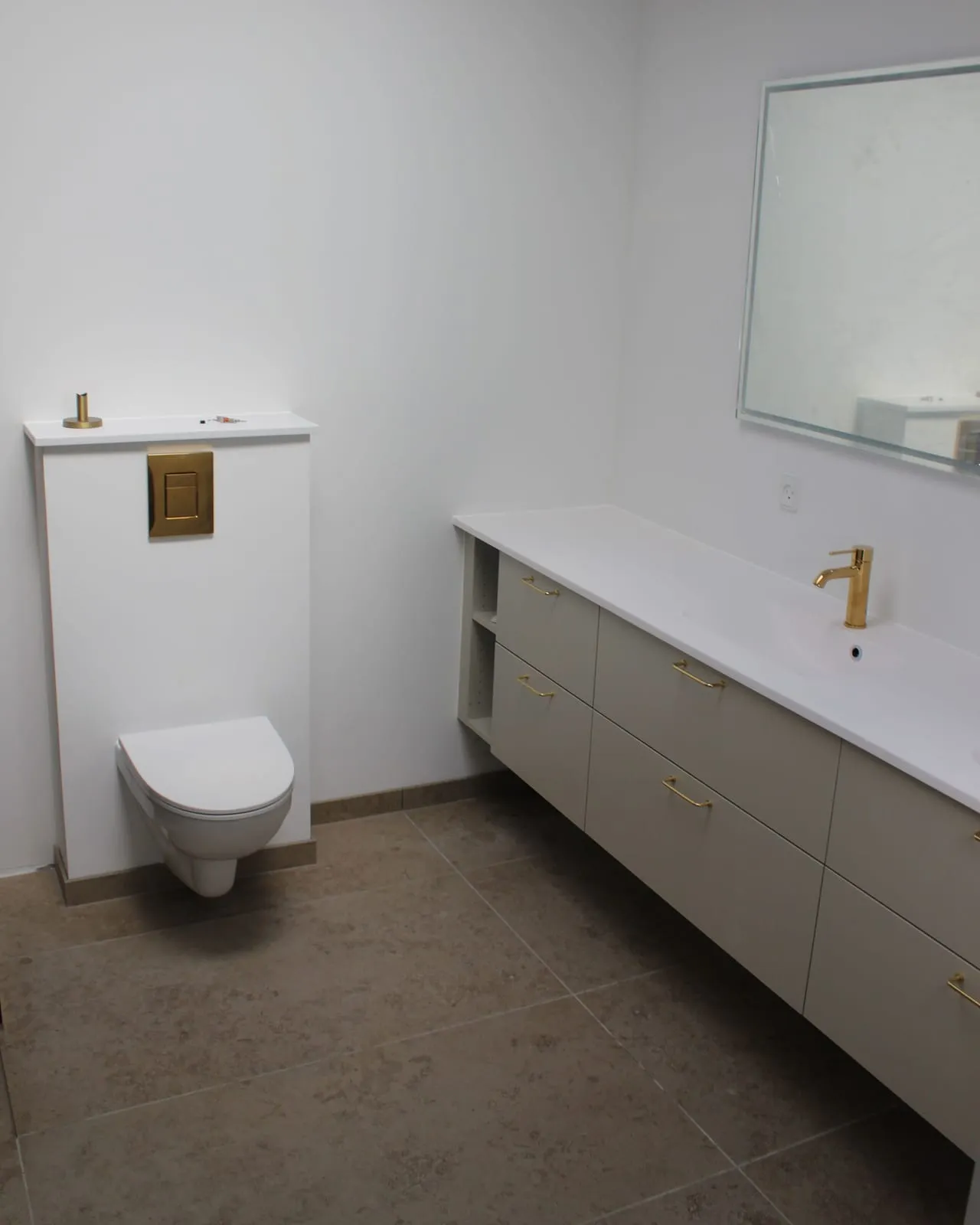Badeværelse med væghængt toilet og badeværelsesmøbel i Kokkedal